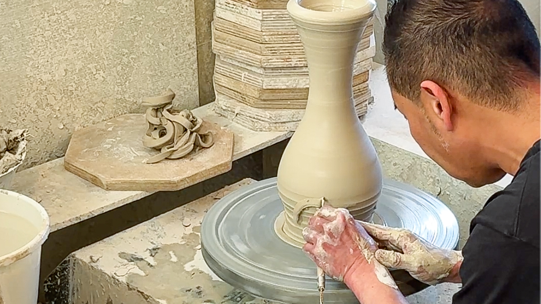 ロクロを回しながら鉋で器を成形する九谷焼作家・中田博士氏